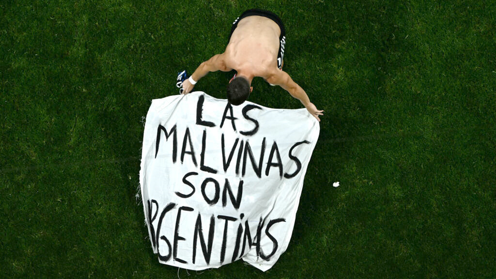 Persona sosteniendo una bandera con la frase Las Malvinas son argentinas